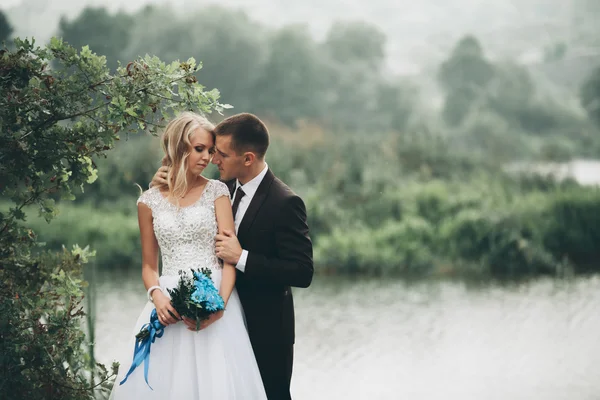 Para romantyczny ślub, mąż i żona, pozowanie w pobliżu pięknego jeziora — Zdjęcie stockowe