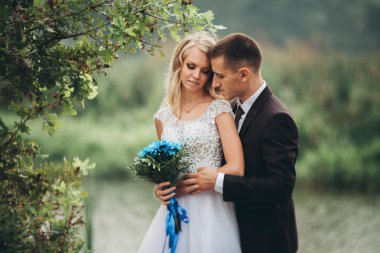 Romantik düğün çift karı güzel göl kenarında poz,