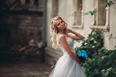 Gelin buketi pozlar arka plan güzel bitkiler üzerinde lüks genç sarışın gelinle