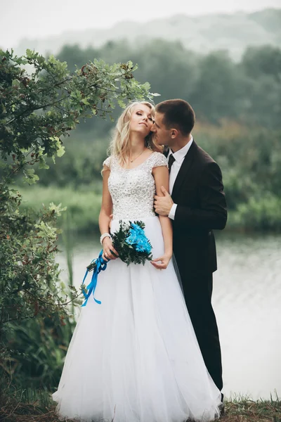 Romantico matrimonio coppia, uomo e moglie, in posa vicino al bellissimo lago — Foto Stock