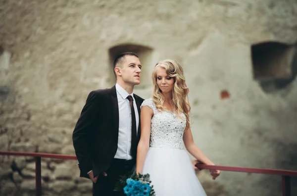 Lyckliga bröllop par kramas och leende varandra på bakgrunden gamla slottet — Stockfoto