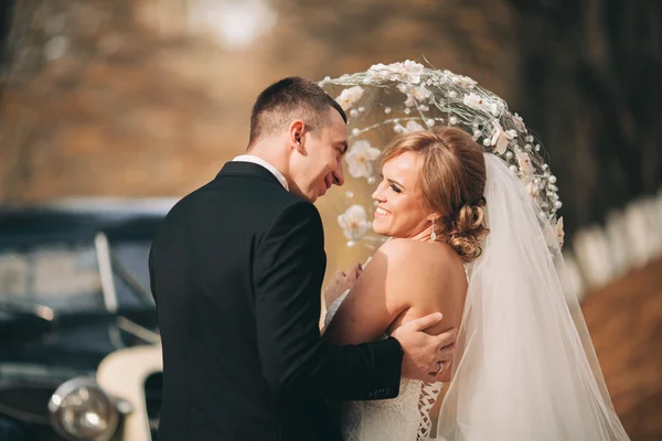 세련 된 웨딩 커플, 키스 하는 신랑 신부와을에 레트로 자동차 근처 포옹 — 스톡 사진