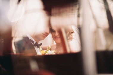 Şık düğün çift, Gelin, damat öpüşme ve retro arabanın yakınında sonbaharda sarılma