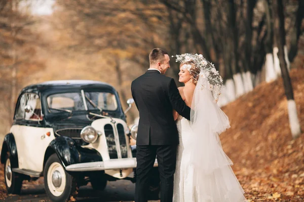 时尚的婚礼夫妇，新娘，新郎亲吻和拥抱附近复古车在秋天 — 图库照片