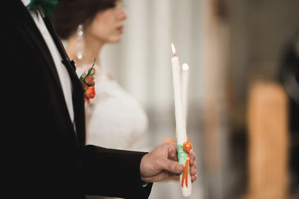 Bröllopspar bida och brudgum gifta sig i en kyrka — Stockfoto