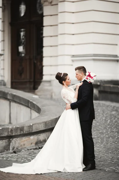 Luxusní manželský pár, nevěsta a ženich pózují ve starém městě — Stock fotografie