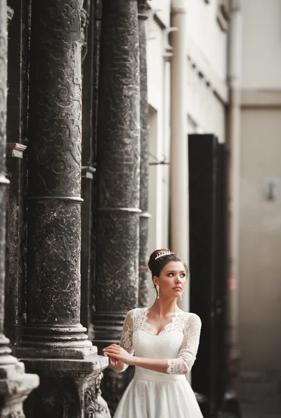 Prachtige bruid met een luxe witte jurk poseren in de oude stad — Stockfoto