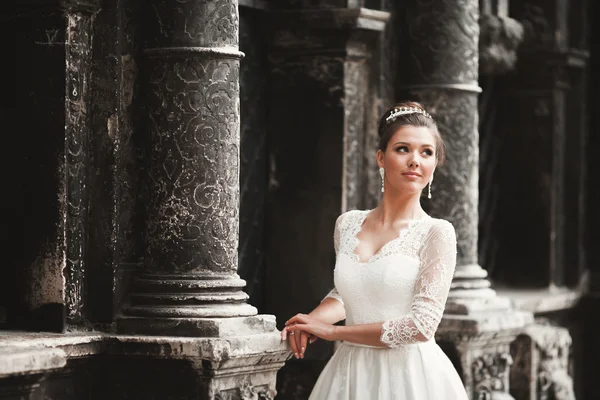 Maravillosa novia con un lujoso vestido blanco posando en el casco antiguo — Foto de Stock