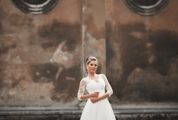 Wonderful bride with a luxurious white dress posing in the old town — Stock Photo, Image