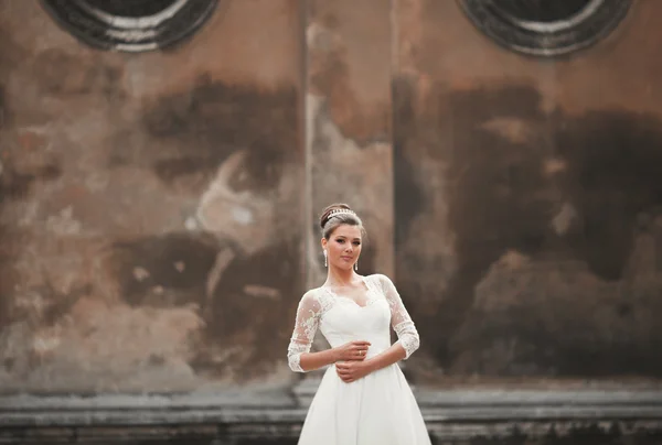 Prachtige bruid met een luxe witte jurk poseren in de oude stad — Stockfoto