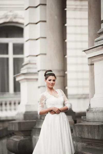 Прекрасная невеста с роскошным белым платьем позирует в старом городе — стоковое фото