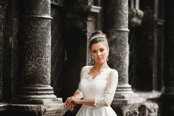 Прекрасная невеста с роскошным белым платьем позирует в старом городе — стоковое фото