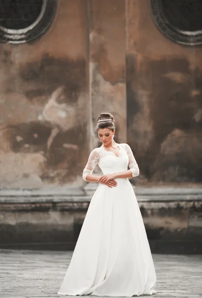 Maravillosa novia con un lujoso vestido blanco posando en el casco antiguo — Foto de Stock