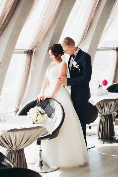 Verheugd huwelijksfeest paar, bruid en bruidegom poseren in hotel — Stockfoto