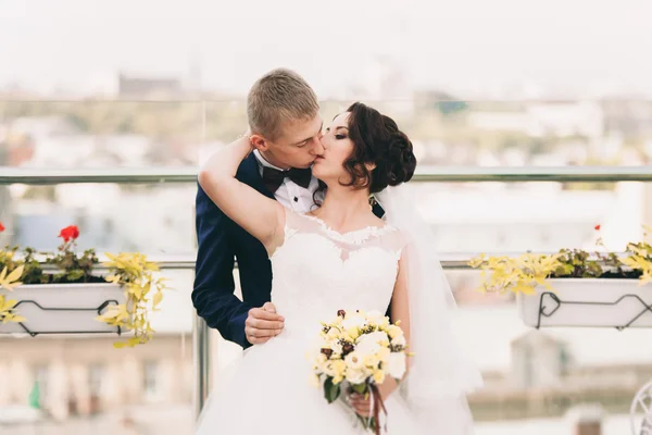Счастливая супружеская пара, невеста, жених целуется с видом на старый город — стоковое фото