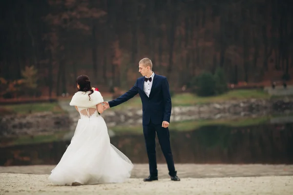 Amor e paixão - beijo do par de casamento jovem casado perto do lago — Fotografia de Stock