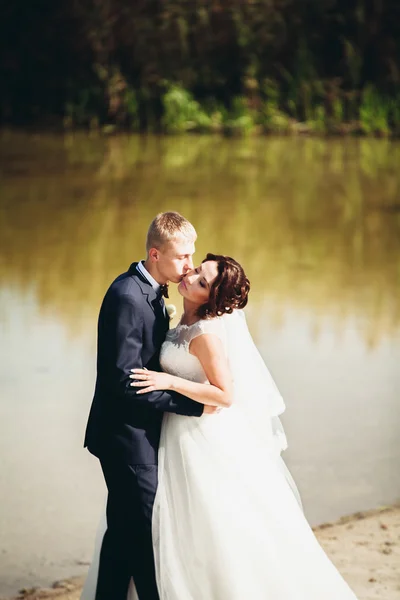 Liefde en passie - kus van getrouwde jonge bruidspaar in de buurt van lake — Stockfoto