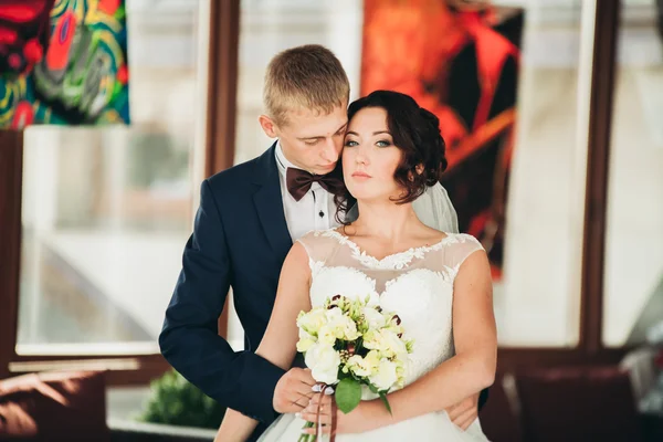 Šťastný Svatební pár, nevěsta a ženich pózuje v hotelu — Stock fotografie