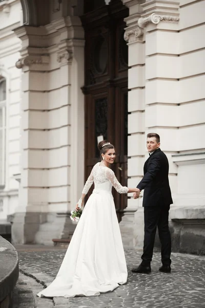 Luxusní manželský pár, nevěsta a ženich pózují ve starém městě — Stock fotografie