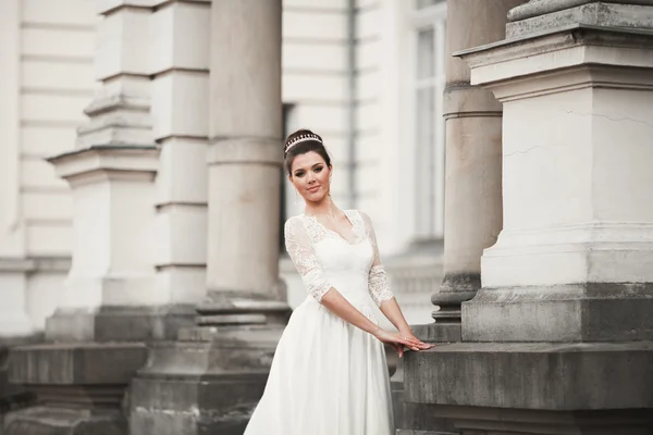 Maravillosa novia con un lujoso vestido blanco posando en el casco antiguo — Foto de Stock