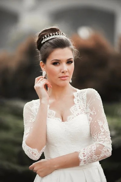 Gyönyörű menyasszony és egy luxus fehér ruhában pózol az óvárosban — Stock Fotó