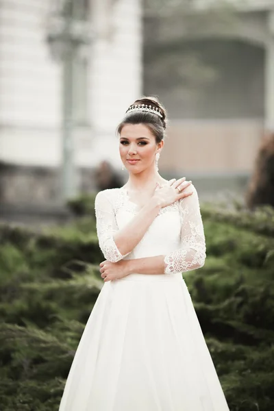 Prachtige bruid met een luxe witte jurk poseren in de oude stad — Stockfoto