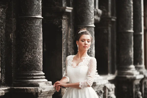 Maravillosa novia con un lujoso vestido blanco posando en el casco antiguo —  Fotos de Stock