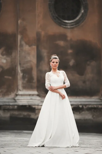Maravillosa novia con un lujoso vestido blanco posando en el casco antiguo — Foto de Stock