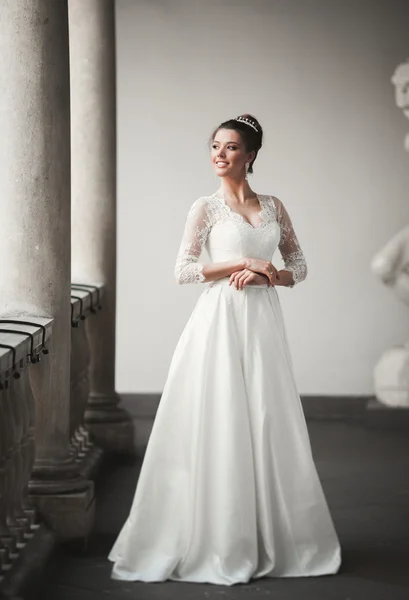 Maravillosa novia con un lujoso vestido blanco posando en el casco antiguo — Foto de Stock