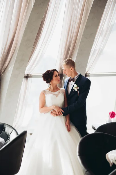 Verheugd huwelijksfeest paar, bruid en bruidegom poseren in hotel — Stockfoto