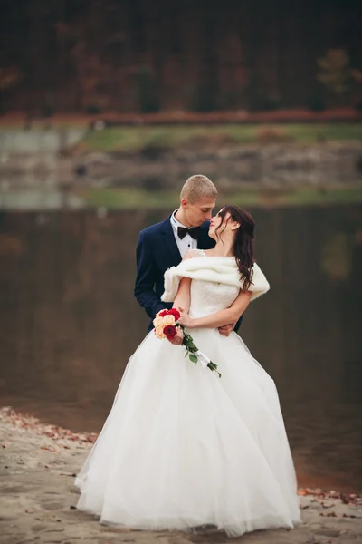 Amore e passione - bacio di coppia nuziale giovane sposata vicino a lago — Foto Stock
