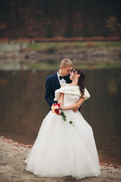 Liefde en passie - kus van getrouwde jonge bruidspaar in de buurt van lake — Stockfoto