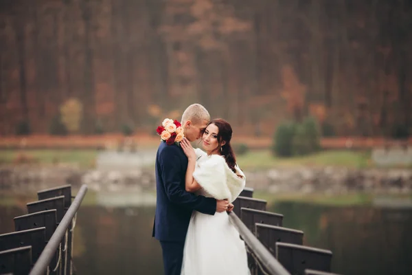 Kärlek och passion - kyss av gift unga brudparet nära lake — Stockfoto