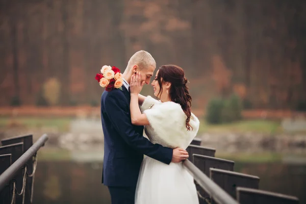 Amore e passione - bacio di coppia nuziale giovane sposata vicino a lago — Foto Stock