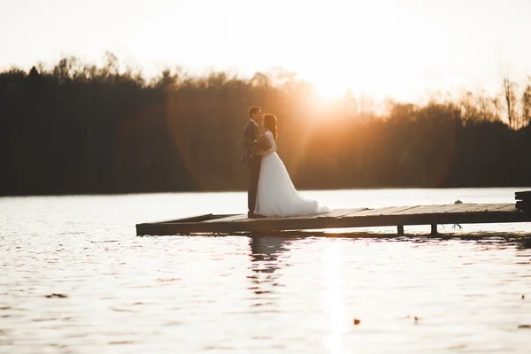Para elegancki ślub piękny pozowanie w pobliżu Jezioro o zachodzie słońca — Zdjęcie stockowe
