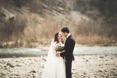 Mutlu evlilik çift, gelin ve damat zemin Dağları nın karşı temiz nehir poz