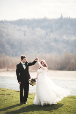 Güzel düğün çift, Gelin, poz ve yüksek Dağları arka planı alanında yürüme damat