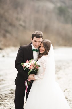 Mutlu evlilik çift, gelin ve damat zemin Dağları nın karşı temiz nehir poz