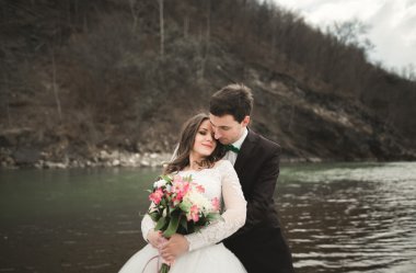Mutlu evlilik çift, gelin ve damat zemin Dağları nın karşı temiz nehir poz