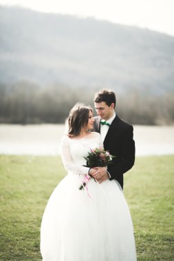 Güzel düğün çift, Gelin, poz ve yüksek Dağları arka planı alanında yürüme damat