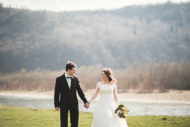 Güzel düğün çift, Gelin, poz ve yüksek Dağları arka planı alanında yürüme damat