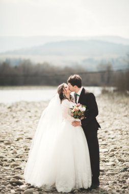 Mutlu evlilik çift, gelin ve damat zemin Dağları nın karşı temiz nehir poz