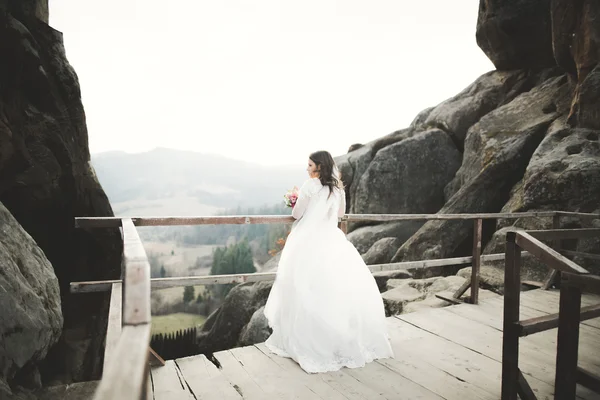 Bela noiva posando perto de rochas com belas vistas — Fotografia de Stock