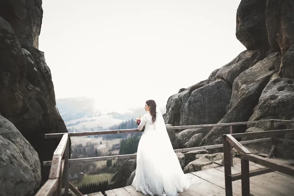 Bela noiva posando perto de rochas com belas vistas — Fotografia de Stock