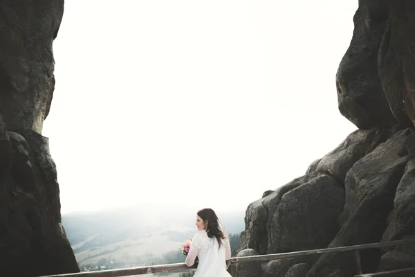 Bela noiva posando perto de rochas com belas vistas — Fotografia de Stock