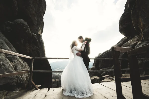 Casal de casamento feliz, noiva e noivo posando perto de pedras com belas vistas — Fotografia de Stock