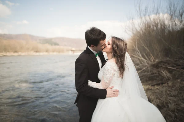 Felice sposi, sposi in posa sul fiume con una splendida vista — Foto Stock