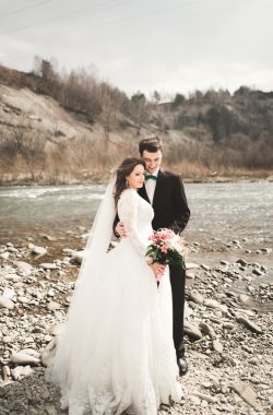 Mutlu evlilik çift, gelin ve damat zemin Dağları nın karşı temiz nehir poz