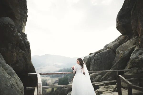 Schöne Braut posiert in der Nähe von Felsen mit schöner Aussicht — Stockfoto