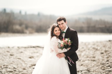 Mutlu evlilik çift, gelin ve damat zemin Dağları nın karşı temiz nehir poz